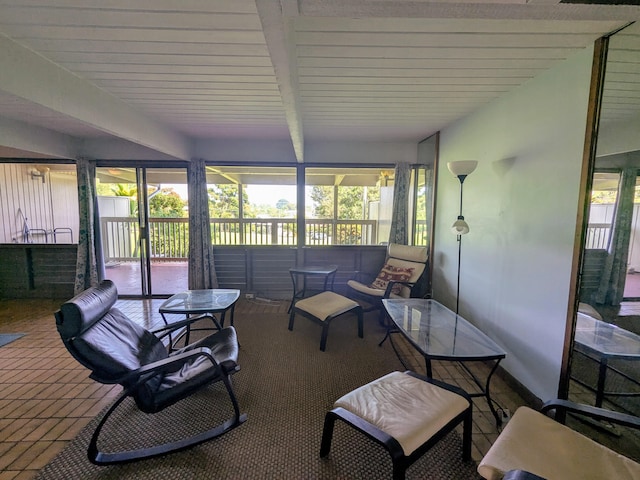 sunroom / solarium featuring plenty of natural light and beamed ceiling