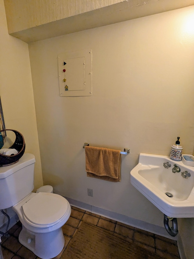 bathroom featuring toilet, tile patterned flooring, and sink