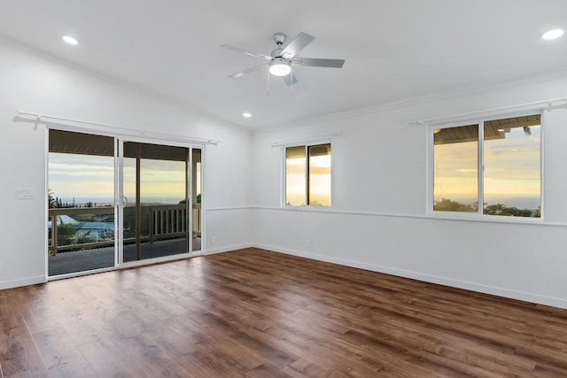 empty room with dark hardwood / wood-style floors, vaulted ceiling, ceiling fan, and ornamental molding