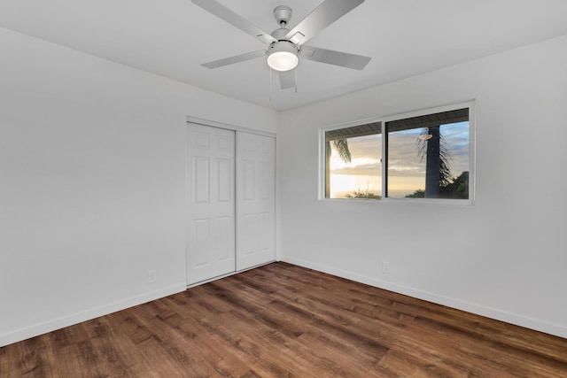 empty room with ceiling fan and dark wood-type flooring