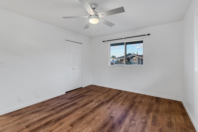 empty room with ceiling fan and dark hardwood / wood-style flooring