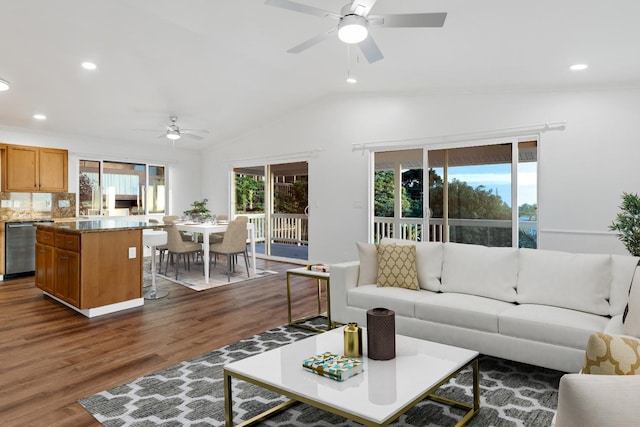 living room with ceiling fan, crown molding, dark wood-type flooring, and vaulted ceiling