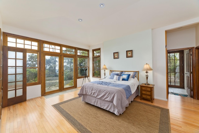 bedroom featuring access to exterior, french doors, and light hardwood / wood-style floors