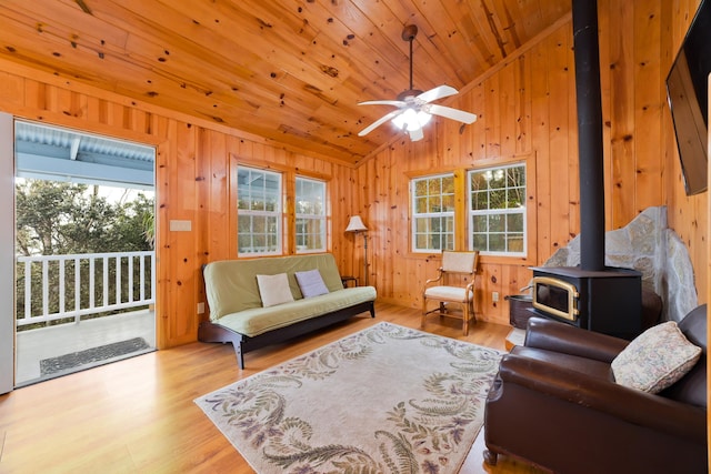 living room featuring wooden ceiling, a wood stove, lofted ceiling, and light hardwood / wood-style flooring