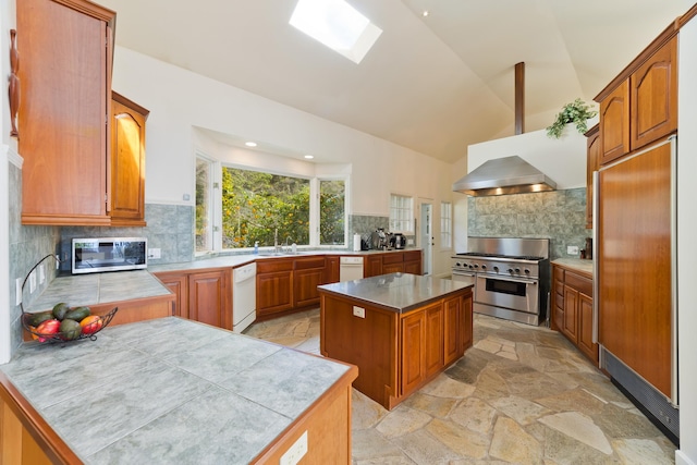 kitchen featuring ventilation hood, premium appliances, a center island, and decorative backsplash