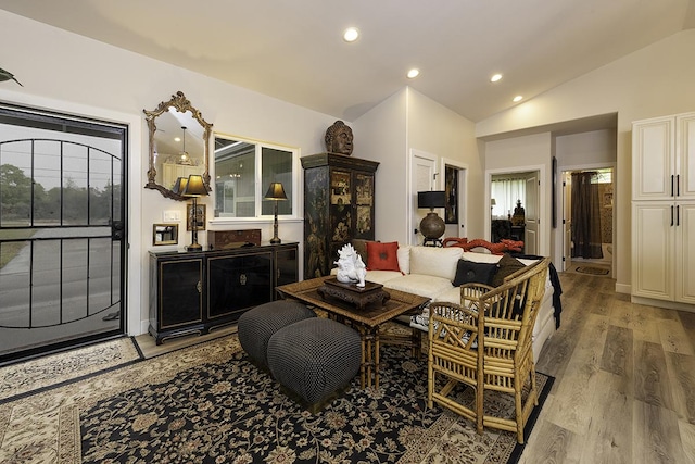 living room featuring vaulted ceiling and light wood-type flooring