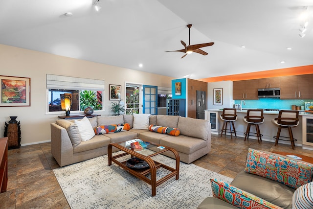 living room with ceiling fan, sink, and vaulted ceiling