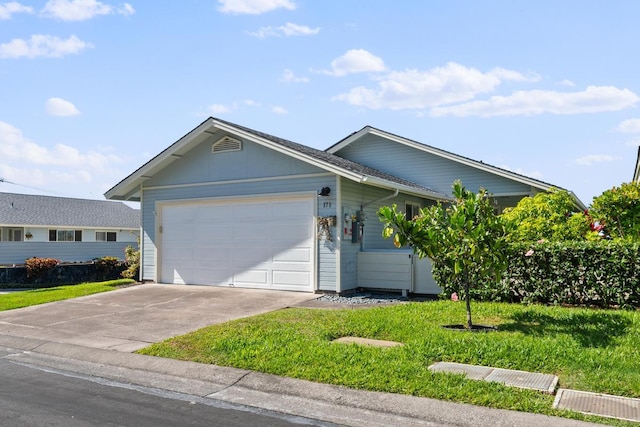 ranch-style house featuring a garage and a front lawn