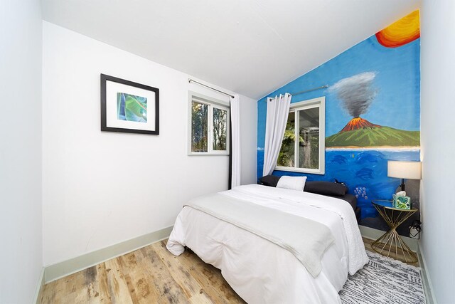 bedroom featuring wood-type flooring and vaulted ceiling