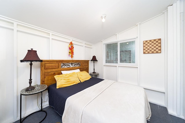 bedroom with dark carpet and lofted ceiling