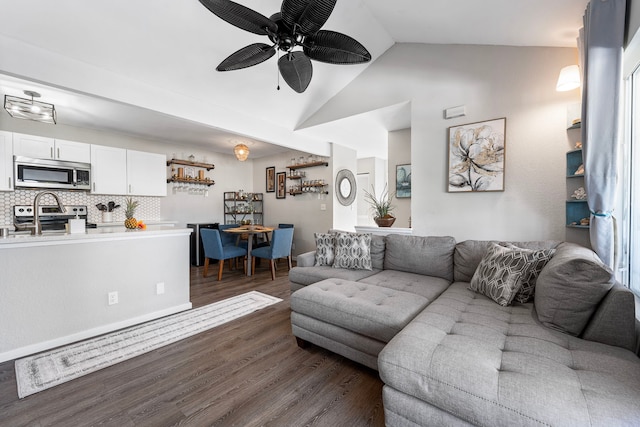 living room featuring vaulted ceiling, ceiling fan, and dark wood-type flooring