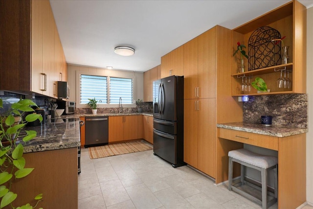 kitchen with dishwasher, dark stone counters, sink, decorative backsplash, and black fridge with ice dispenser