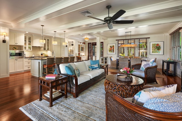 living room featuring beam ceiling, ceiling fan, crown molding, and dark hardwood / wood-style flooring