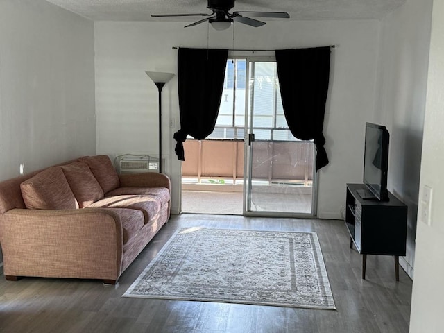 living room featuring ceiling fan, hardwood / wood-style floors, and a textured ceiling