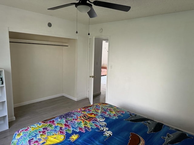 bedroom featuring hardwood / wood-style floors, a closet, and ceiling fan