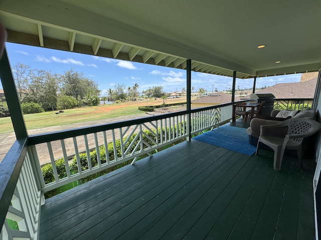 wooden terrace with area for grilling and a yard