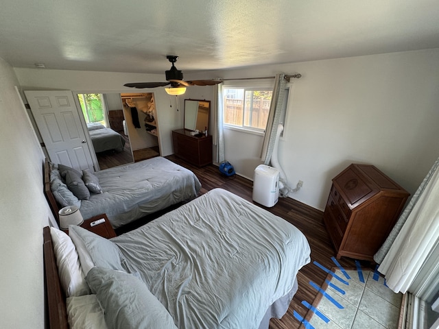 bedroom featuring hardwood / wood-style flooring, ceiling fan, and multiple windows