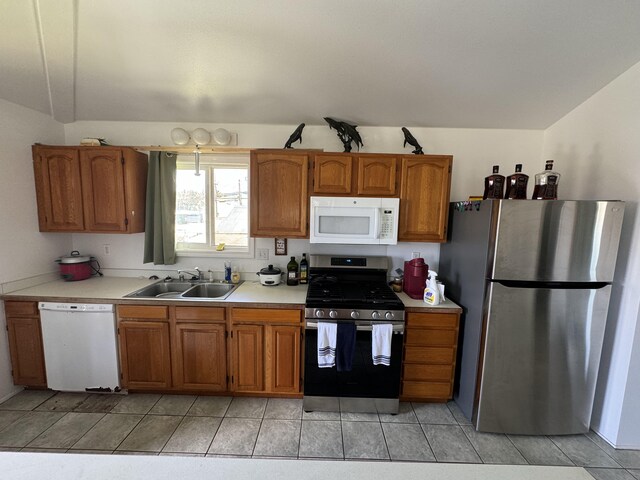 kitchen with light tile patterned floors, stainless steel appliances, and sink