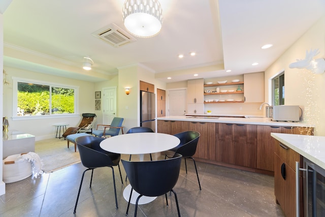 dining room featuring wine cooler, sink, and ornamental molding