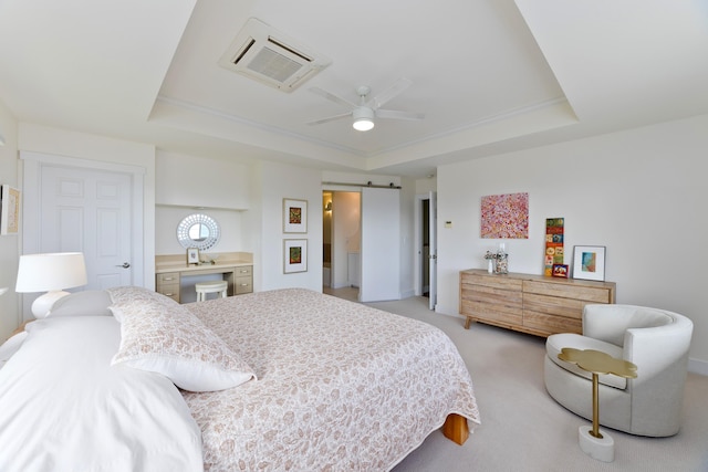 bedroom with a raised ceiling, a barn door, ceiling fan, and light carpet