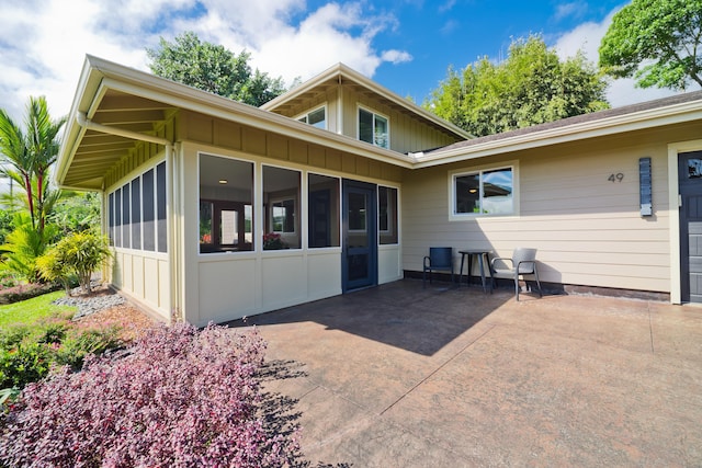 rear view of property featuring a patio area and a sunroom