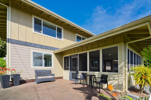 back of property with a patio area and a sunroom