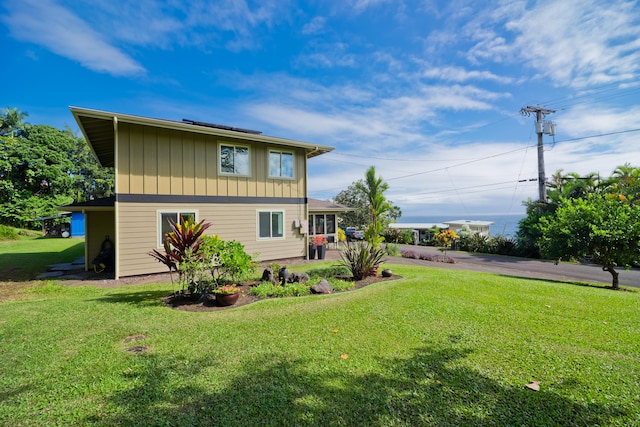 rear view of property featuring a lawn and a patio