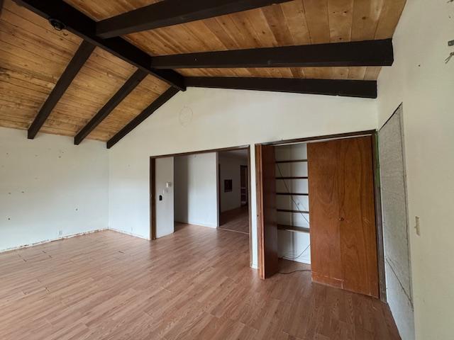 interior space with wooden ceiling, high vaulted ceiling, hardwood / wood-style flooring, beam ceiling, and multiple closets