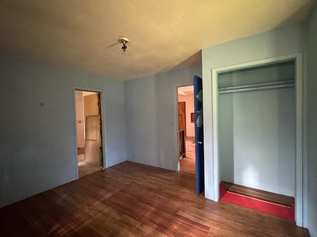 unfurnished bedroom featuring wood-type flooring and a closet