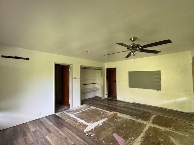 unfurnished bedroom with dark hardwood / wood-style floors, ensuite bath, and ceiling fan