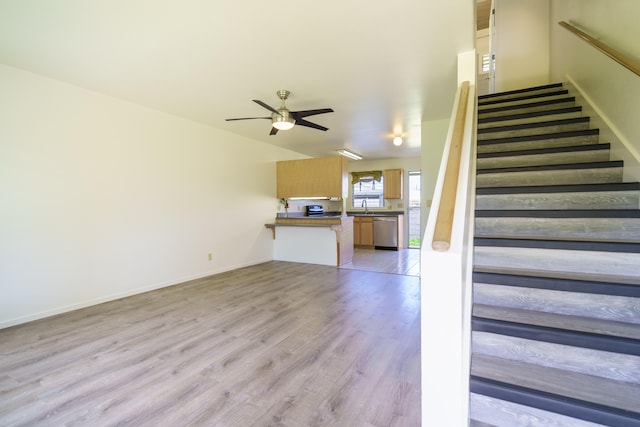 staircase with wood finished floors, baseboards, and ceiling fan