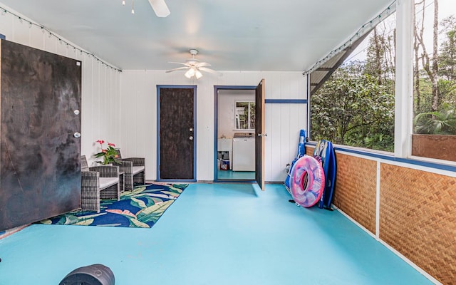 sunroom / solarium featuring washer / clothes dryer and ceiling fan