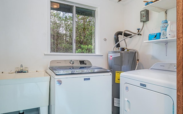 laundry area featuring electric water heater, sink, and washing machine and clothes dryer