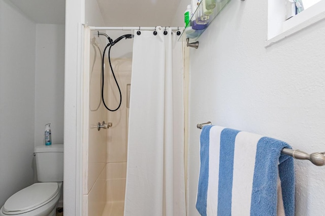 bathroom featuring a shower with curtain and toilet