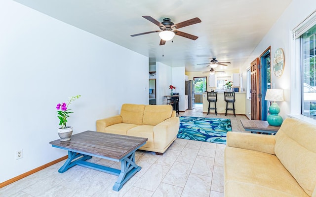 living room with ceiling fan and a healthy amount of sunlight