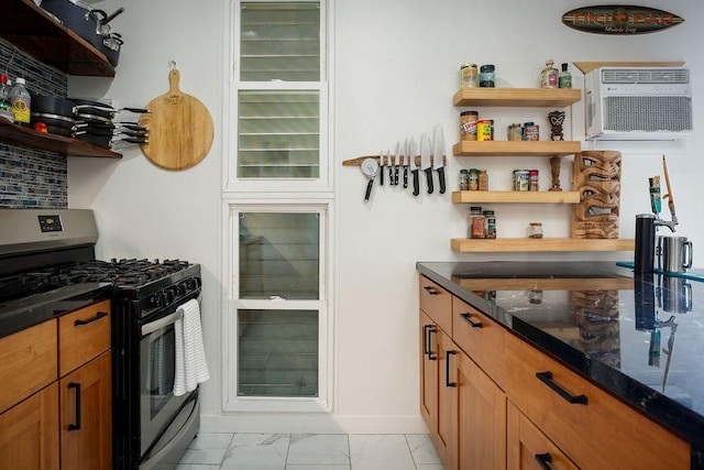 kitchen featuring stainless steel gas range oven and a wall mounted air conditioner