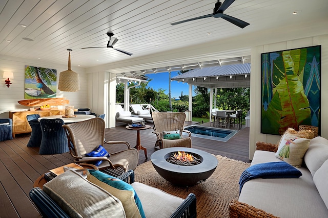 view of patio featuring an outdoor living space with a fire pit and a deck