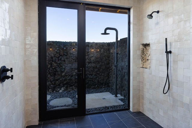 bathroom with a tile shower and tile patterned floors