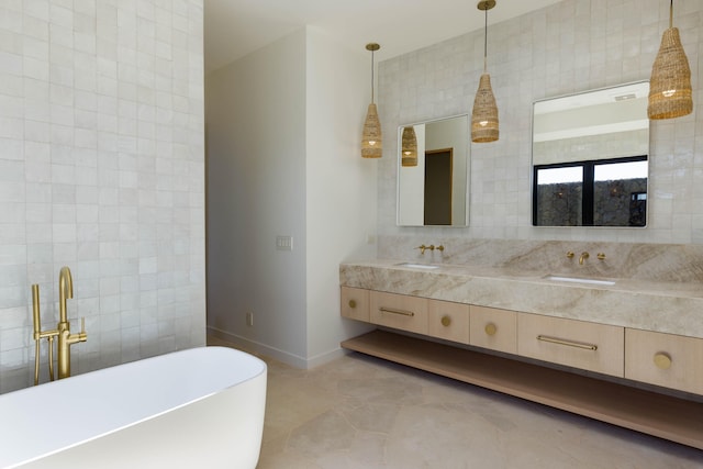 bathroom with tile patterned floors, a bathing tub, vanity, and tile walls