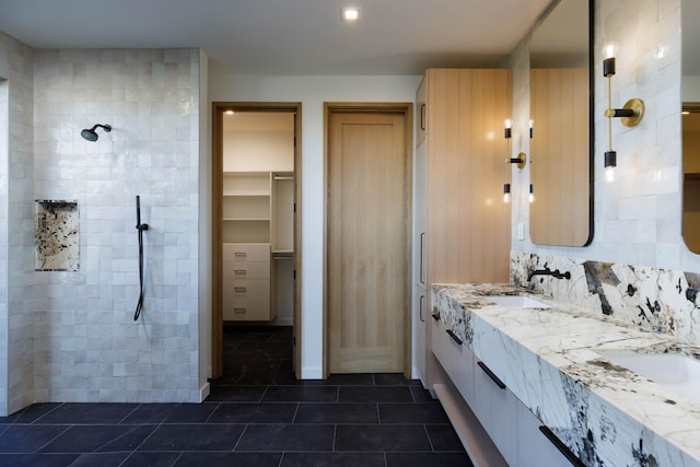 bathroom with tile patterned floors, vanity, and a tile shower