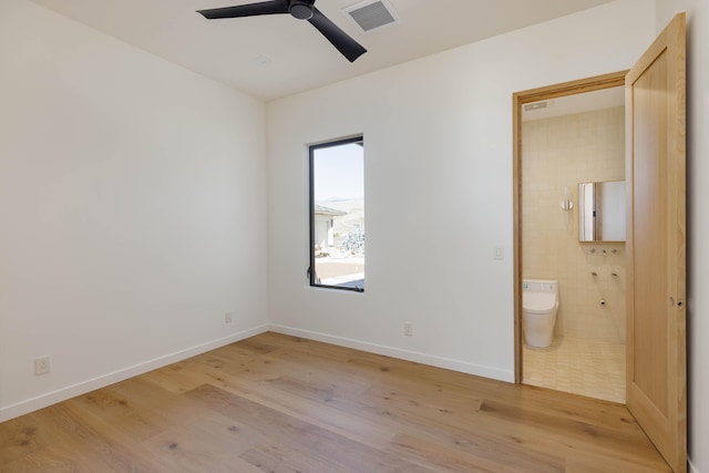 unfurnished bedroom with connected bathroom, ceiling fan, and light hardwood / wood-style floors