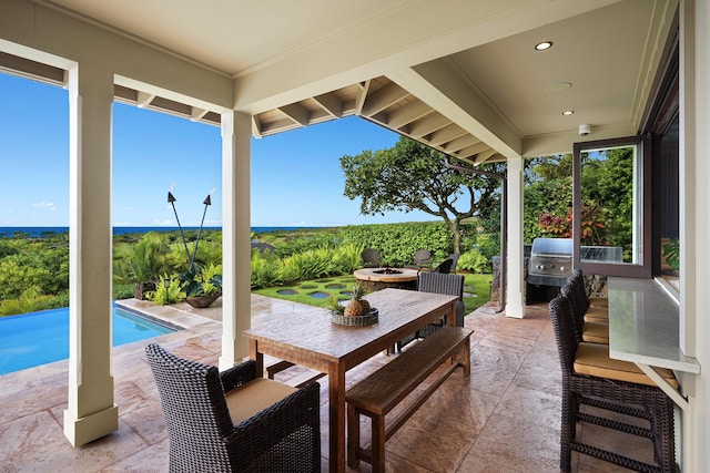 view of patio with area for grilling, a fenced in pool, and an outdoor fire pit