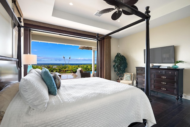 bedroom featuring a tray ceiling, ceiling fan, and dark hardwood / wood-style flooring