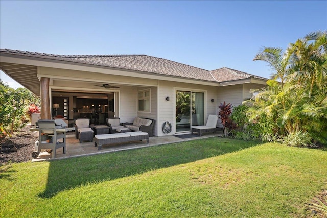 back of house with an outdoor living space, ceiling fan, a patio area, and a lawn