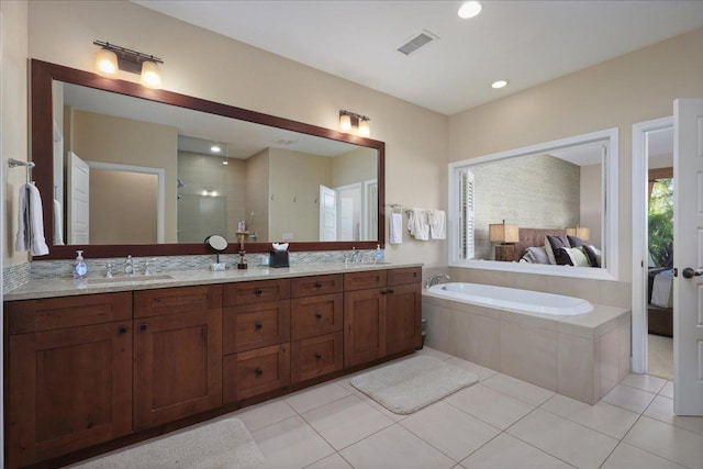 bathroom with tile patterned flooring, vanity, and shower with separate bathtub