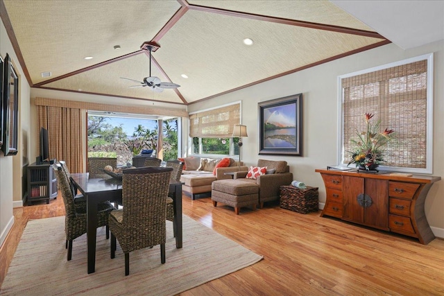 dining space with lofted ceiling, ornamental molding, a textured ceiling, and light hardwood / wood-style flooring