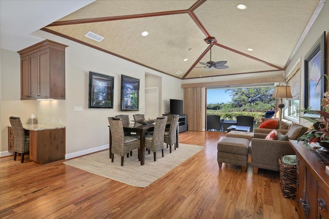 dining space featuring a textured ceiling, light hardwood / wood-style floors, and crown molding