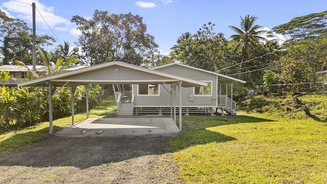 view of front of home with a carport and a front lawn