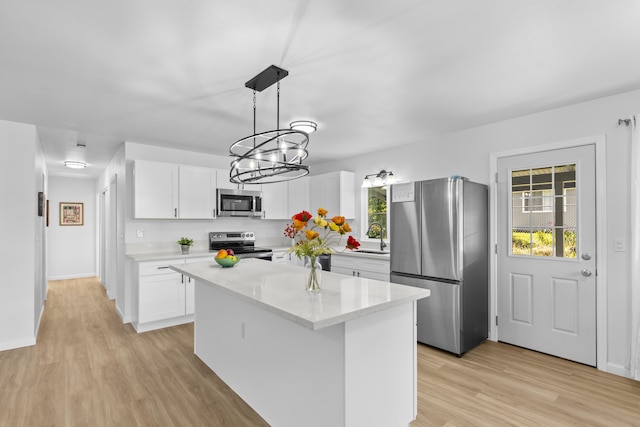 kitchen featuring white cabinets, appliances with stainless steel finishes, a center island, and pendant lighting