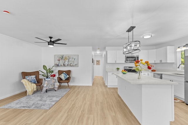 kitchen featuring a center island, white cabinetry, hanging light fixtures, and appliances with stainless steel finishes